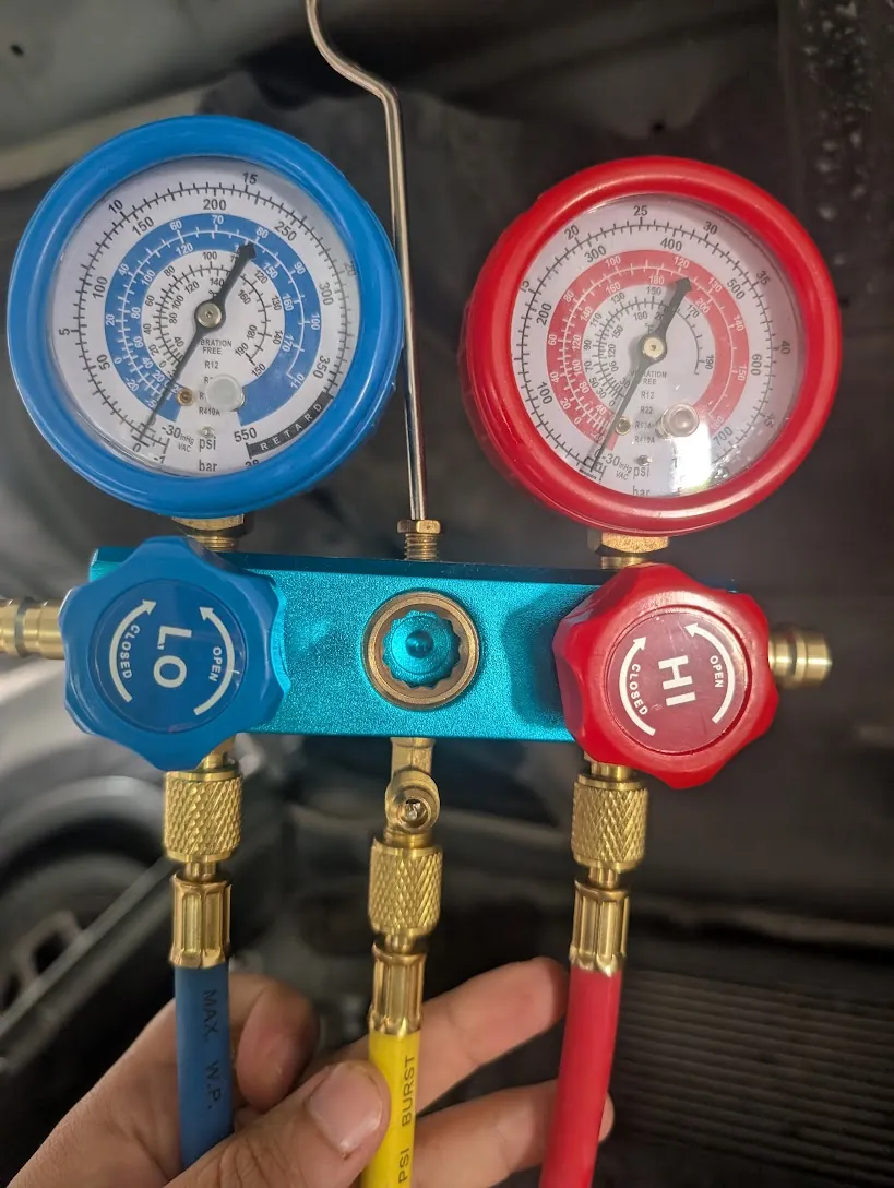 Manifold gauge set with low-side and high-side gauges connected during motor-vehicle air-conditioning service